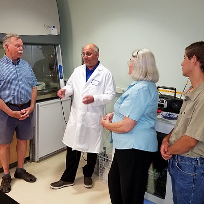 UGA Skidaway Institute scientist Marc Frischer (white coat) discusses his research with visitors at a 2018 Open Lab Night.