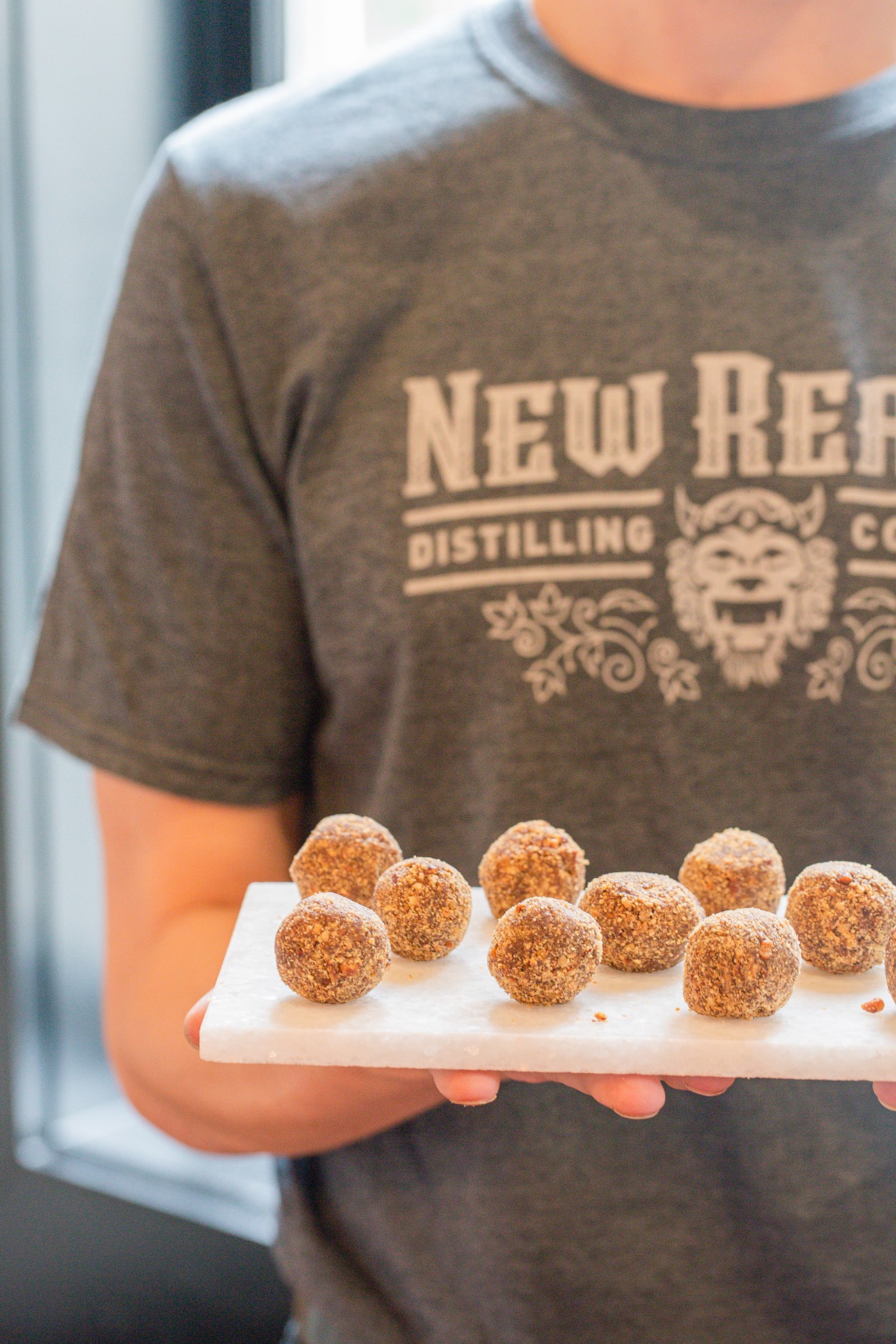 A Staff member of the New Realm Brewing offers guests Bourbon Truffles to pair with their drinks at the VIP event held April 16 at the brewery’s new location in the Historic District of Savannah.